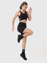 Top deportivo negro con breteles anchos y diseño cruzado en el frente.