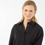 Camisa negra con bordado inglés, corte estándar, cuello clásico y cierre frontal con botones.