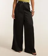 Pantalón pantalona de corte sastre, color negro, con trabillas en la cintura, cinturón con hebilla de metal y pliegues delanteros.