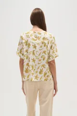 Blusa marrón con estampado de hojas color crema, cuello en V y mangas cortas. Corte holgado.