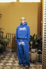 Pantalón azul de felpa de algodón con corte oversize y doble cintura simulando boxer. Estampa de perro blanco en el muslo.