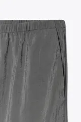 Pantalón palazzo color gris topo de tejido fluido, con cintura elástica ajustable con cordones y bolsillos laterales.