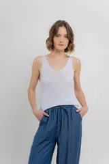 Musculosa tejida color gris claro, con escote en V delantero y trasero, de calce relajado.