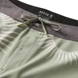 Short de baño color verde con estampado de soles blancos.