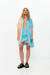 Minifalda celeste con estampado de soles naranjas y amarre lateral.