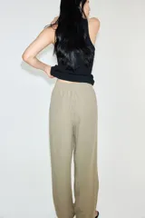 Pantalón tobillero color beige de corte holgado en tejido liviano de mezcla de lino. Modelo de tiro alto con elástico revestido y cordón para ajustar fino en la cintura, bolsillos al bies y piernas ajustadas.