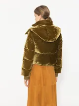 Campera de velvet verde con capucha desmontable, cierre central y detalles en broches.