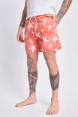 Short de baño color naranja con estampado de estrellas de mar blancas, cintura elástica con cordón ajustable.