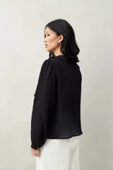Camisa negra de tencel liviana con volados románticos y manga corta.
