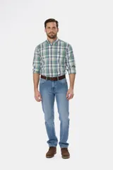 Pantalón de jean azul oscuro de corte recto y tiro medio. Incluye cinturón de cuero marrón y botas de gamuza marrón.