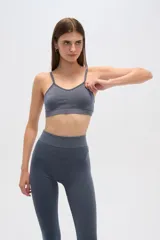 Top deportivo gris con breteles finos, corte al cuerpo y cuello en V.