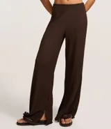 Pantalón largo color beige, de poliéster texturizado, con cintura elástica y bolsillos laterales.