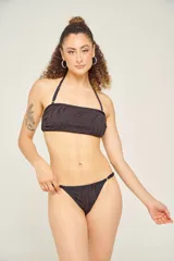 Traje de baño de dos piezas color negro con estampado de cebra. El corpiño es strapless con tirantes finos removibles y la bombacha es tipo colaless con tiras finas ajustables en los laterales.