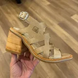 Sandalia negra de cuero con textura de piel de serpiente, diseño de tiras entrecruzadas y hebilla ajustable en el tobillo. Posee una plataforma gruesa y un taco ancho y alto.