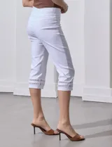 Pantalón capri blanco de gabardina elastizada con bolsillos simulados, pretina ancha, corte recto y detalle de puntilla en el ruedo.