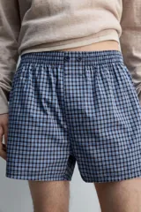 Calzoncillo tipo bóxer confeccionado en popelín de algodón con estampado de cuadros azules y blancos.