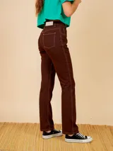Pantalón jean marrón de corte recto, con bolsillos delanteros y traseros, y costuras en hilo blanco.