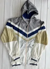 Campera deportiva con capucha, color gris, beige, negro y amarillo.