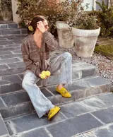 Alpargatas tipo mocasín de gamuza color amarillo mostaza, con detalle de flecos en la capellada.