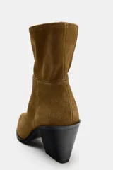 Botín de gamuza color marrón con puntera y cierre lateral con cremallera. Tacón bloque de 8 cm de altura.