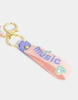 Llavero con forma de cámara de fotos rosada con detalles en lila y celeste. Incluye un dije con forma de conejo con auriculares y un strap con la palabra "music".