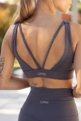 Top deportivo negro con breteles finos cruzados en la espalda y logo de la marca en el lateral izquierdo.