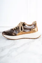 Zapatillas deportivas de cuero metalizado color cobre y plateado, con cordones color beige, suela de goma blanca y logo de la marca en el lateral.