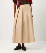 Pollera midi color beige, con pliegues delanteros y cinturón fino ajustable. Confeccionada en tricolina de algodón certificado BCI.