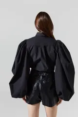 Camisa negra de popelina de algodón, con mangas voluminosas y cuello clásico.