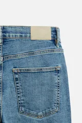 Pantalón de jean azul oscuro, corte slim fit, tiro medio, cinco bolsillos, tejido elástico y efecto lavado.