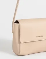 Bandolera color beige de cuerina con solapa, tag metálico y correa larga regulable.