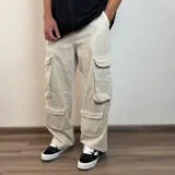 Pantalón jean color beige, de corte holgado y estilo cargo, con múltiples bolsillos laterales.