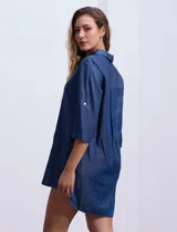 Vestido corto de tencel color azul denim, con cuello solapa, escote en V y mangas 3/4 regulables con presilla y botón.