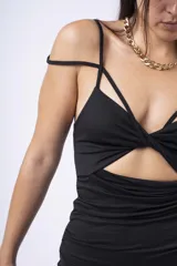 Vestido corto negro con breteles finos, escote con aberturas geométricas y frunces en la falda.