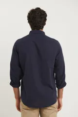 Camisa azul marino de lino y algodón, con cuello abotonado, manga larga con puños enrollados, bolsillo de parche en el pecho y cierre frontal con botones.
