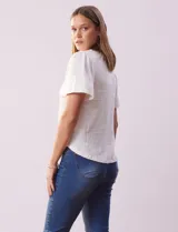 Remera blanca de poliéster, rayón y elastano, con cuello a la base y escote en V. Manga corta amplia bordada. Marca Cable & Gauge.