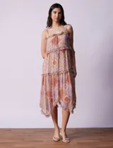 Vestido midi de gasa estampada con motivos geométricos en tonos naranja, lila y beige. Tiene breteles finos regulables, escote en V con volados y falda asimétrica con volados.