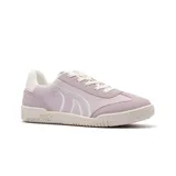 Championes deportivos de caña baja, color blanco hueso o crema, con cordones. Presentan texturas en el cuero y un diseño que recuerda a zapatillas de tenis retro.