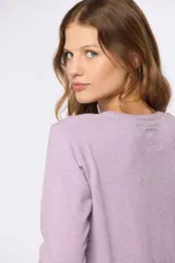 Buzo lila de hilo de algodón, con cuello redondo a la base y mangas largas.