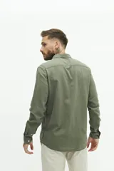Camisa de lino color beige, de manga larga, corte semi slim y logo bordado en el pecho.