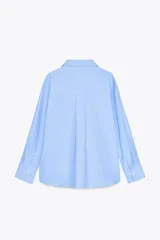 Camisa celeste de corte clásico, cuello solapa, escote en pico y manga larga.