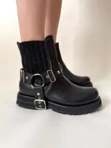 Botín negro de cuero vacuno con elásticos laterales y estribo desmontable con apliques y herrajes metálicos color níquel.