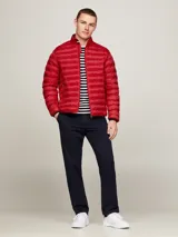 Campera acolchada roja de poliéster reciclado, con cuello alto, cierre de cremallera, bolsillos laterales y logo de Tommy Hilfiger bordado en el pecho.