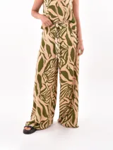 Pantalón palazzo con estampado de hojas en tonos beige y verde.
