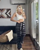 Pantalón de hilo color marrón con rayas horizontales blancas, corte holgado y cintura con cordón ajustable.