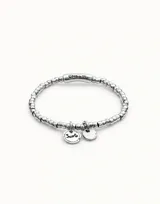 Pulsera artesanal con baño de plata y base elástica, compuesta por cuentas redondeadas y charm con la palabra 'suerte'.