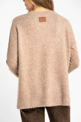 Sweater color beige de tejido texturado, con cuello redondo y mangas largas.