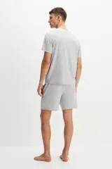 Conjunto de pijama gris claro melange, compuesto por una remera de manga corta con cuello redondo y un short con cintura elástica ajustable con cordón y bolsillos laterales.