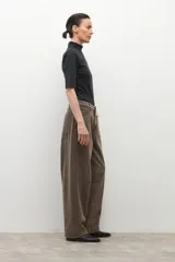 Pantalón de jean estilo barrel, color marrón oscuro con efecto desgastado. Presenta un calce holgado y tiro alto.