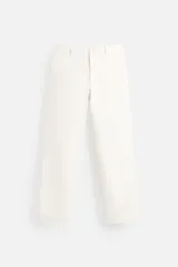 Pantalón chino color blanco hueso, corte slim fit, confeccionado en tejido técnico de secado rápido. Cuenta con bolsillos frontales y traseros de vivo. Cierre frontal con cremallera y botón.